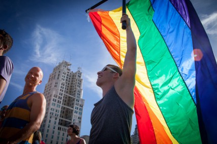 Wes Warner (right) holds a gay pride flag during a rally celebrating the Supreme Court's gay marriage ruling at Ilus W. Davis Park in Kansas City, Mo. on Wednesday (June 26).  RNS photo by Sally Morrow