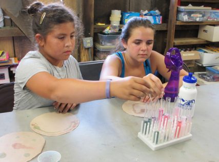 Campers Piper (left, no last name provided) and Meghan Judge (right) paint cabbage juice-soaked coffee filters with various liquidsduring a pH painting elective session at Camp Quest Chesapeake. RNS photo by Corrie Mitchell