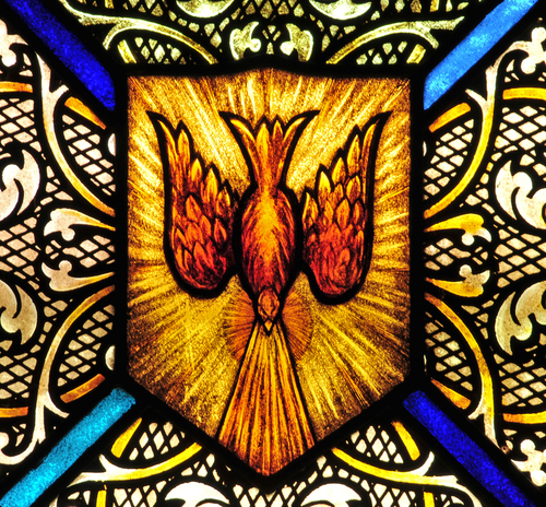 Stained glass window with symbol of Holy Spirit