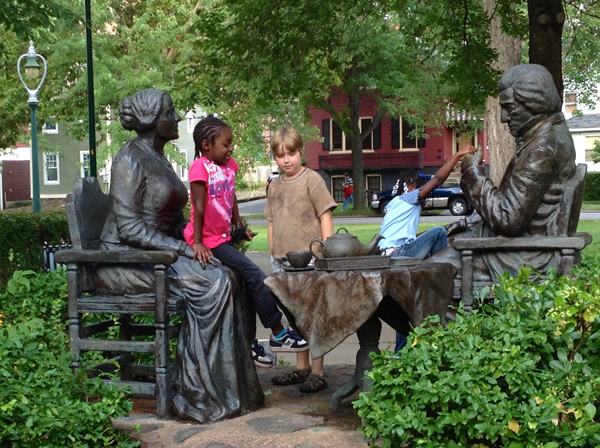 Children play on a statue of abolitionists and freethinkers Susan B. Anthony and Frederick Douglass in Rochester, N.Y. RNS photo by Kimberly Winston