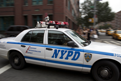 An NYPD car drives through the streets of New York City.