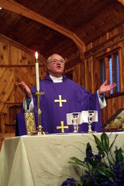 George Carey, former archbishop of Canterbury, celebrates Communion during a meeting of the Anglican primates in North Carolina in 2001. Photo by James Rosenthal / Anglican Communion News Service