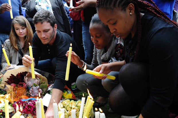 Mourners light candles outside the late Former President Nelson Mandela's Home in Houghton, Johannesburg. (Photo: GCIS)