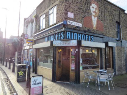 Hyman Rinkoff's handlebar moustache greets customers above Rinkoffs deli and café on Vallance Road in Whitechapel, London. RNS photo by Brian Pellot