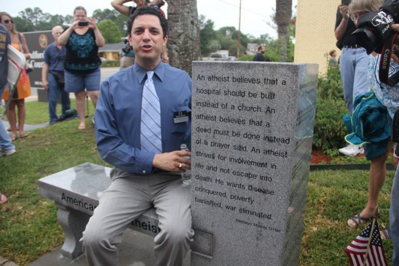 American Atheist President David Silverman sits on the Atheist monument at the Bradford County Courthouse in Starke, Fla.