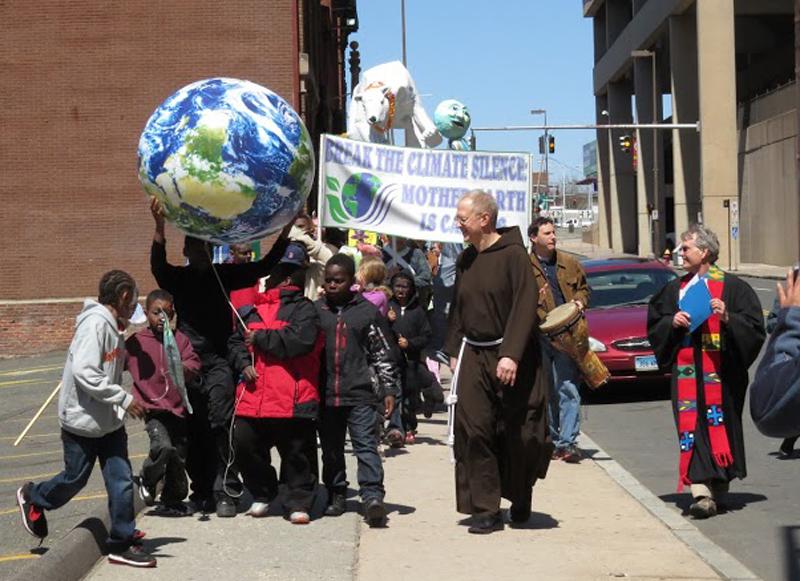 Rev. Sam Fuller, center, a Capuchin Franciscan priest from Middleton, Ct. leads a group of children on Earth Day 2013 during a march to bring awareness to climate change in Hartford. Photo courtesy of Patrick Watson