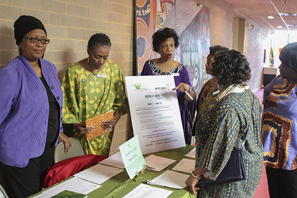 Rosalyn Priester, Pat Owens, and Adrienne Wynn stand at the Earth Day display encouraging members to shrink their carbon footprint. Photo courtesy of Trinity UCC Photography Ministry