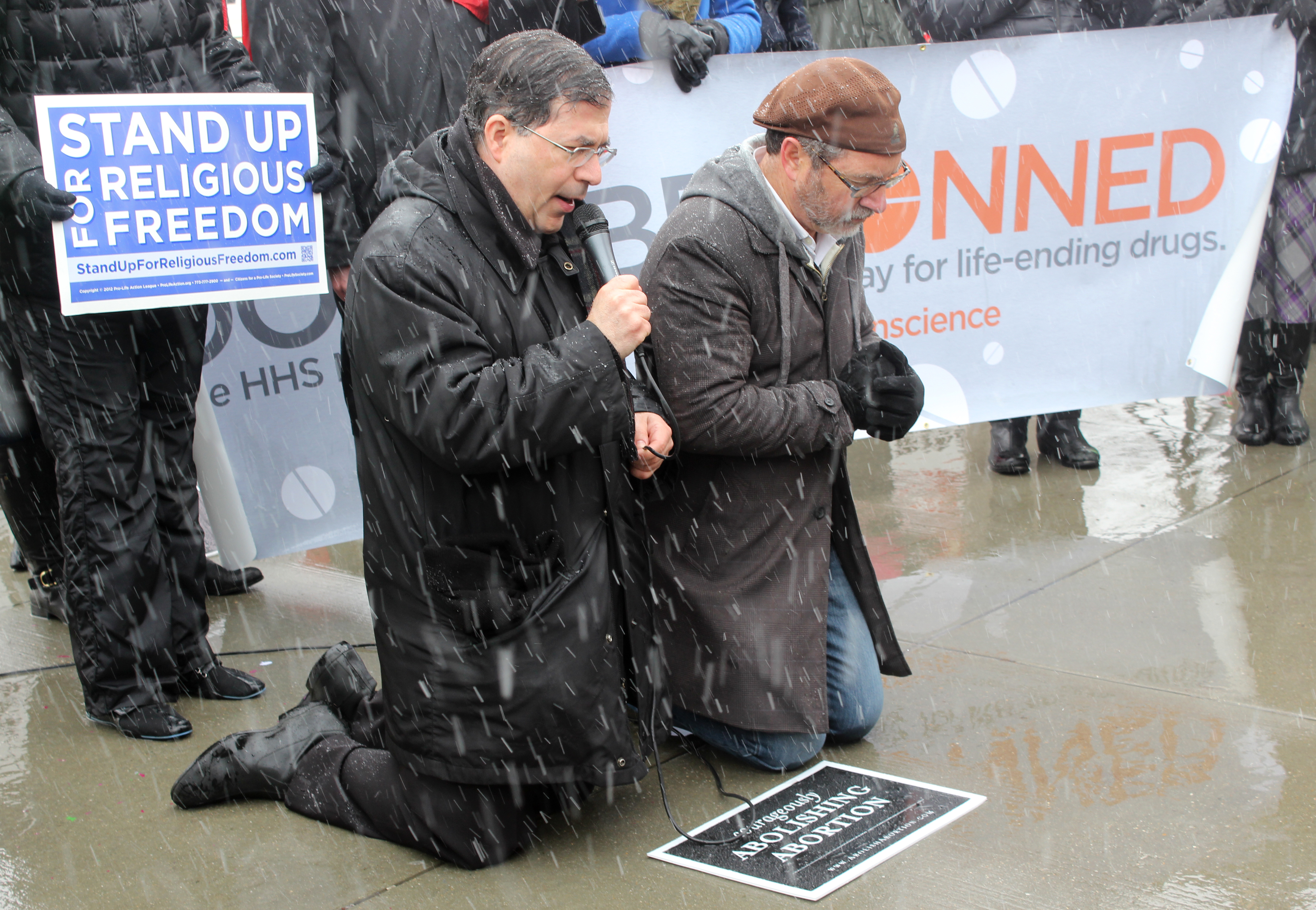 The Rev. Frank Pavone of Priests for Life, left, leads a prayer beside Rev. Patrick Mahoney, right, in front of the Supreme Court, as they support businesses challenging the contraception mandate of the Affordable Care Act on March 25, 2014. RNS photo by Adelle M. Banks