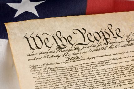 The U.S. Constitution with an american flag.