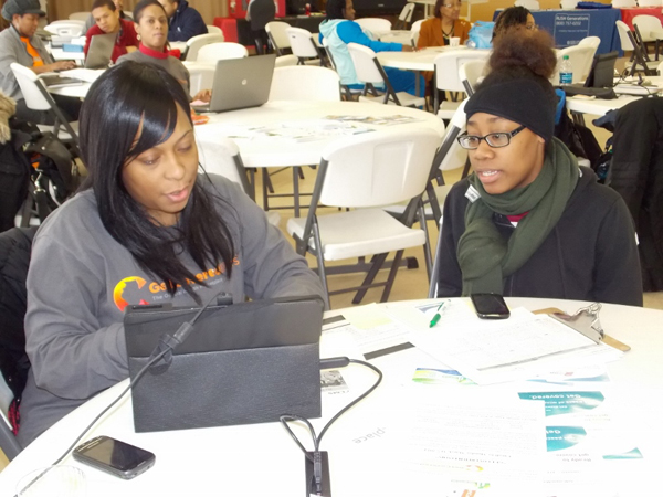 April Caldwell, right, age 19, successfully enrolls in Medicaid with help from Latonya Rover, a counselor for Beloved Community Family Wellness Center, at a Get Covered America health care enrollment event at the Allen Metropolitan CME Church in Chicago. Photo courtesy of Get Covered America
