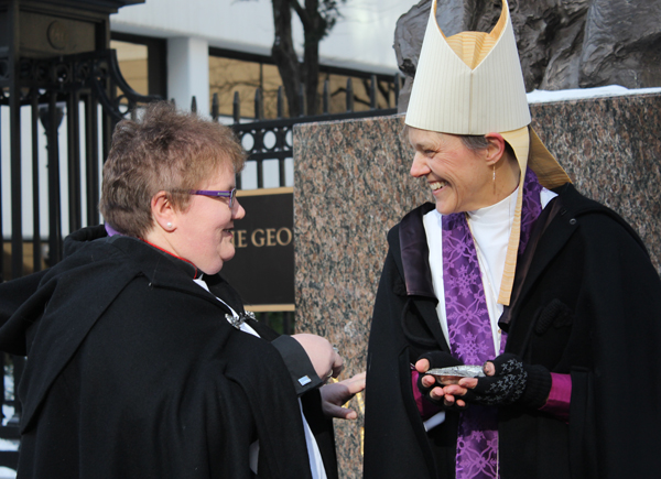 Canon Sue Pinnington of England, left, talks with Bishop Mariann Edgar Budde, leader of the Episcopal Diocese of Washington during “Ashes to  Go” near the Foggy Bottom Metro station in Washington, D.C., on Ash Wednesday (March 5, 2014). RNS photo by Adelle M. Banks