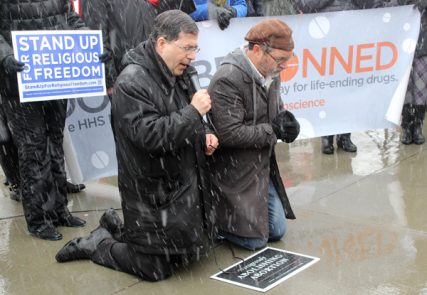 Rev. Frank Pavone of Priests for Life, left, leads a prayer beside Rev. Patrick Mahoney right, in front of the Supreme Court, as they support businesses challenging the contraception mandate of the Affordable Care Act on Tuesday (March 25). RNS photo by Adelle M. Banks