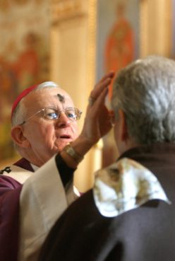 The Most Rev. John G. Vlasny, the Archbishop of Portland, his forehead smudged with ashes, performs the Ash Wednesday ceremony on parishioners in Portland (Feb. 8, 2002). Photo by Michael Lloyd