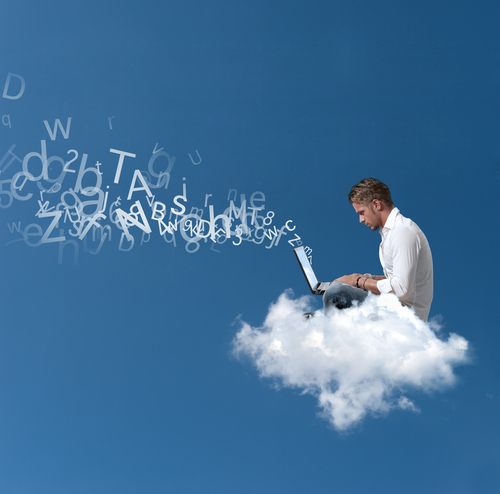 A man working on a computer and sitting on a cloud.
