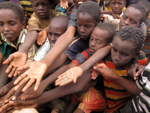 Unidentified children stretch out their hands at the Dadaab refugee camp. Unequal distribution of resources is a major issues cited in the pope's encyclical on the environment. 