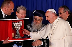 Pope Francis accepts a gift of a menorah as he visits with Israel's two chief rabbis, Sephardic Rabbi Yitzhak Yosef, with beard, and Ashkenazi Rabbi David Lau, not pictured, at the Heichal Shlomo center in Jerusalem