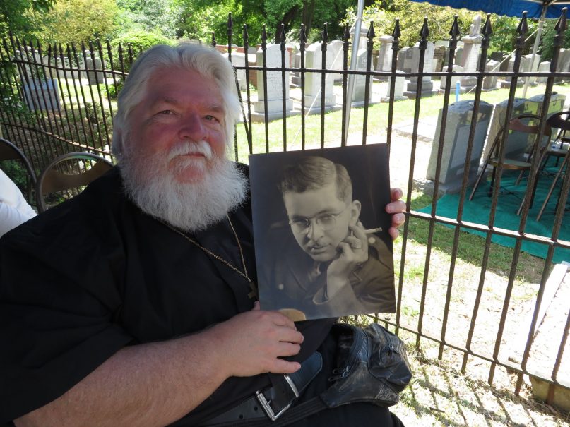 Joseph Corsbie holds up a photo of his father, David Walter Corsbie Jr., who came into possession of ashes from the Dachau concentration camp during his military service.