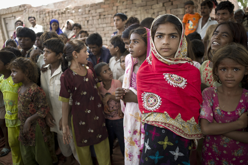 Unidentified children wait for food from a relief team on August 2, 2012 in Lahore, Pakistan. 