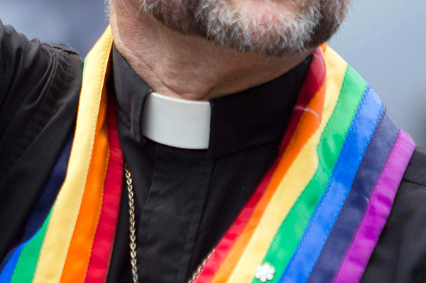 A priest wearing a rainbow-colored vestment makes an appearance during Toronto Pride in 2011.