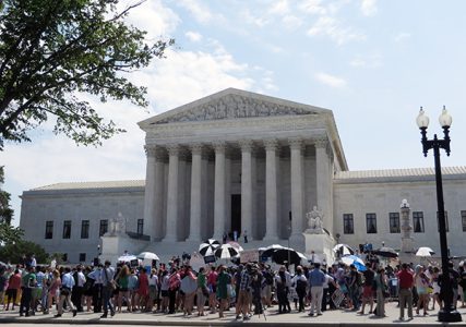 Citizens rally on the steps of the Supreme Court on Monday (June 30), after it sided with the evangelical owners of Hobby Lobby Stores Inc., ruling 5-4 that the arts-and-crafts chain does not have to offer insurance for types of birth control that conflict with company owners’ religious beliefs.