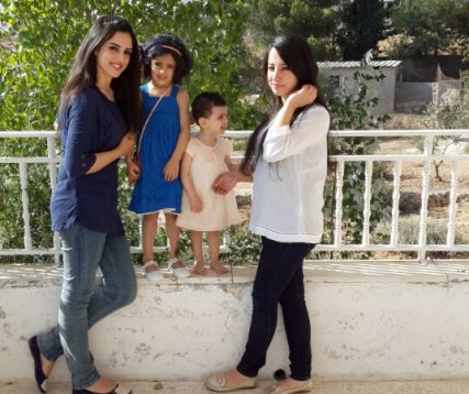 Members of the Dawod family, from left, cousins Haya, 21, Taleen, 4, Dema, 18 months and Noor, 19, soak up the sun on their balcony during their family's Eid al-Fitr celebration, which marks the end of the monthlong fast of Ramadan. The Dawods celebrate Eid with a feast of laffa, or roasted lamb, hummus and locally grown vegetables.