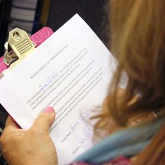 A woman signs a release form at the United Methodist Building before taking part in a protest in which more than 100 religious leaders and immigration advocates were arrested at the White House on July 31, 2014.