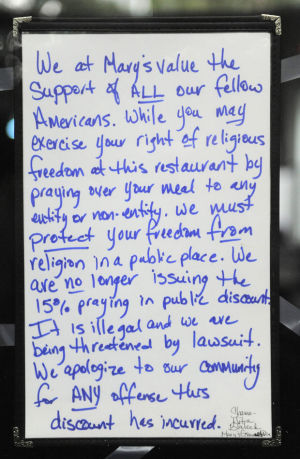On Thursday (Aug. 6), a handwritten board near the front door of Mary's Gourmet Diner in Winston-Salem, N.C., announced that the restaurant would no longer offer a prayer discount. Photo by Bruce Chapman/Winston-Salem Journal *Note to eds: This photo may not be republished without permission from the Winston-Salem Journal. RNS editors: This photo may NOT be used with any other story. Do not republish.