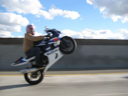 Motorcyclist doing a wheelie on the freeway in Ontario, Canada.