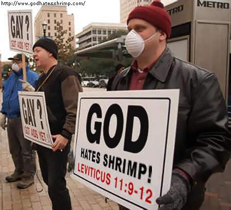 A photo of people protesting discrimination against gays by holding posters reading 'God hates shrimp'.