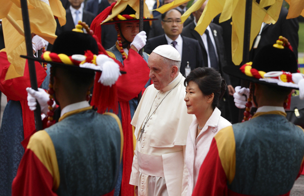 Pope Francis passes through a color guard with South Korean President Park Geun-hye after attending a welcoming ceremony in the garden of the presidential Blue House in Seoul on Thursday (Aug. 14). Photo by Paul Haring, courtesy of Catholic News Service