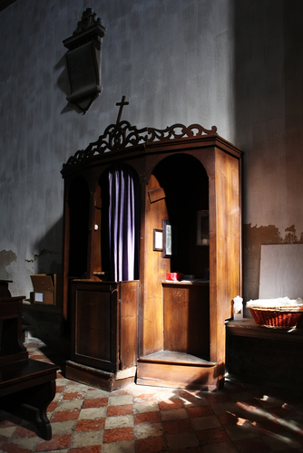 Christian confessional in mysterious light.