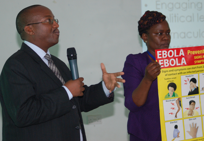 Dr. Ian Njeru from Kenya's Ministry of Health explains to religious leaders, theologians and health professionals how Ebola is spread. He spoke at a conference in Nairobi, Kenya. The Rev. Pauline Njiru, the Eastern African coordinator of the Ecumenical HIV and AIDS Initiative in Africa, holds a poster about Ebola prevention. Religion News Service photo by Fredrick Nzwili