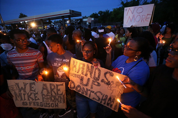 (RNS1-aug14) Left to right, Keith Lovett, Melik Smith, Victoria Smith, Linda Smith and Antonio McDonald, hold candles during a gathering of people at the QuikTrip in Ferguson, Mo., on Thursday (Aug. 14). For use with RNS-FERGUSON-VIGIL, transmitted on August 14, 2014, Photo By David Carson, courtesy of St. Louis Post-Dispatch. - See more at: http://chrisstedman.religionnews.com/2014/08/21/ferguson-atheists-care-can/#sthash.fwf9dkzJ.dpuf