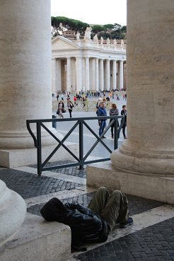  A homeless man sits under the right colonnade close to where the showers are going to be built in St. Peter's square at the Vatican on Thursday (Nov 13, 2014). Religion News Service photo by Josephine McKenna