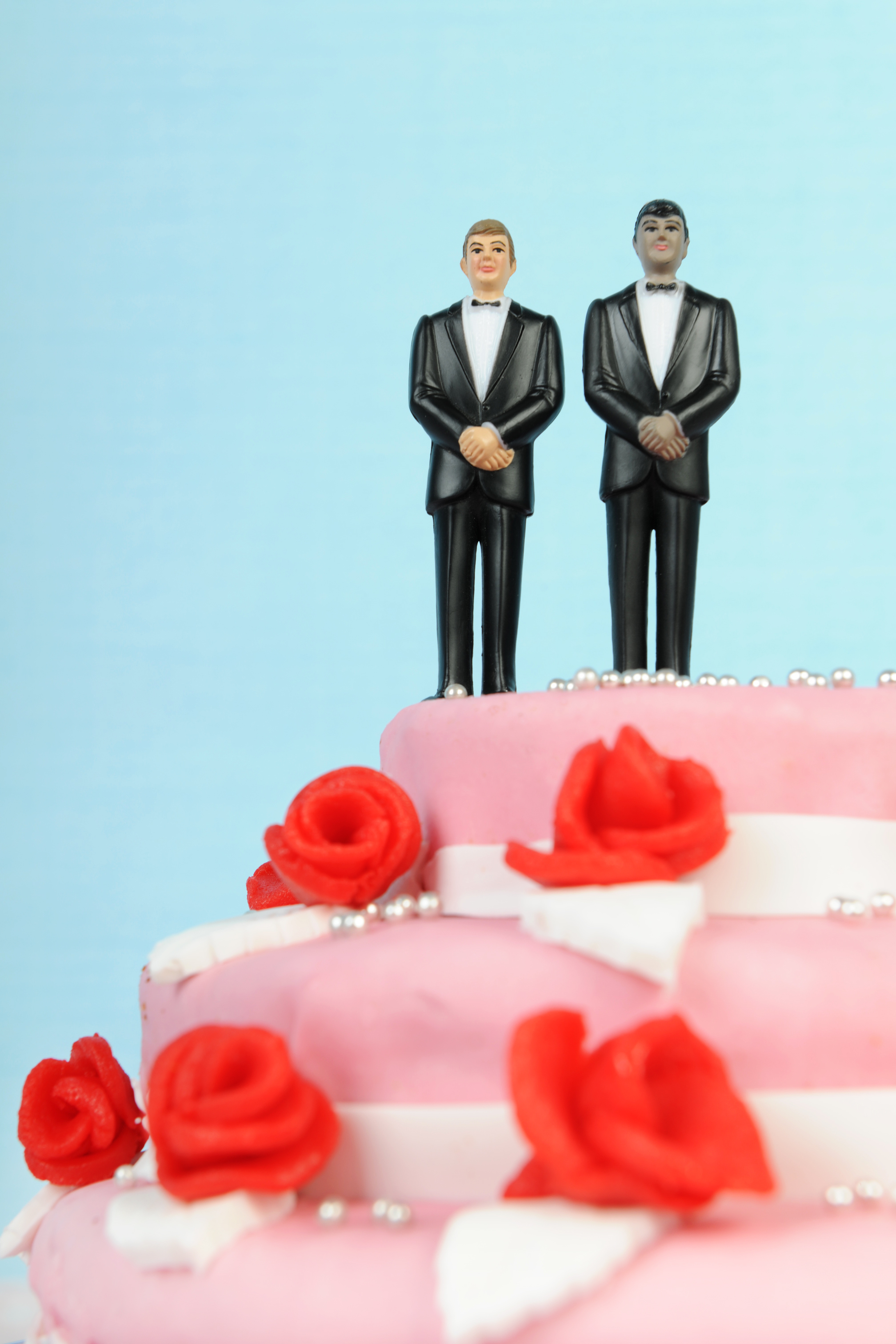 Wedding cake with groom figures on top.