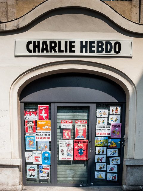 A Charlie Hebdo building with cartoons on the doors.