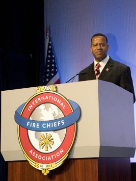 Kelvin Cochran, former Atlanta fire chief, speaks at the podium after being sworn in at the annual convention of International Fire Chiefs in Dallas, Tex., on August 27, 2009. 