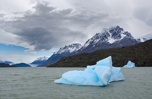 Shatter of blue iceberg melts in front of The Gray Glacier in Patagonia, Chile.