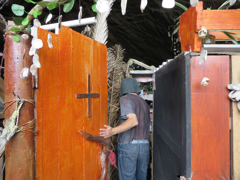 Clifford Brandon enters a room through a door with a cross on it inside Clifford's cave. Religion News Service photo by Brian Pellot
