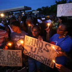 Left to right, Keith Lovett, Melik Smith, Victoria Smith, Linda Smith and Antonio McDonald, hold candles during a gathering of people at the QuikTrip in Ferguson, Mo., on Thursday (Aug. 14). For use with RNS-FERGUSON-VIGIL, transmitted on August 14, 2014, Photo By David Carson, courtesy of St. Louis Post-Dispatch