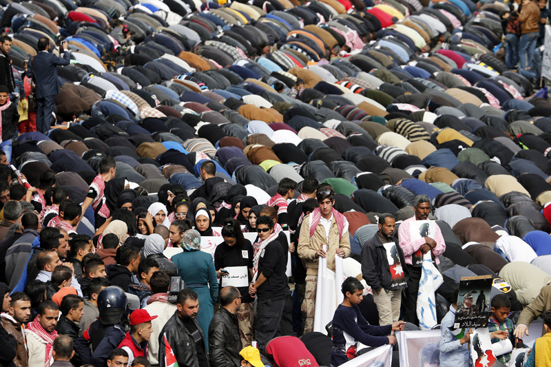 Muslims perform Friday prayers along a street outside al-Husainy mosque before a march in downtown Amman on February 6, 2015. Thousands of Jordanians gathered to show their loyalty to the King and to show solidarity with the family of the pilot, Muath al-Kasasbeh, killed by Islamic State. Photo courtesy of REUTERS/Muhammad Hamed 
*Editors: This photo may only be republished with RNS-ISLAM-POLL, originally transmitted on February 12, 2015.