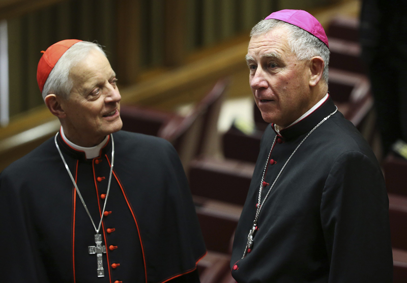 Bishop John Atcherley Dew (R) and cardinal Donald William Wuerl speak before Pope Francis leads a consistory at the Vatican February 12, 2015. Pope Francis, starting two days of closed-door meetings with the world's Roman Catholic cardinals, on Thursday called for greater efficiency and transparency in the Church's troubled central administration, the Curia.   REUTERS/Alessandro Bianchi  (VATICAN - Tags: RELIGION)