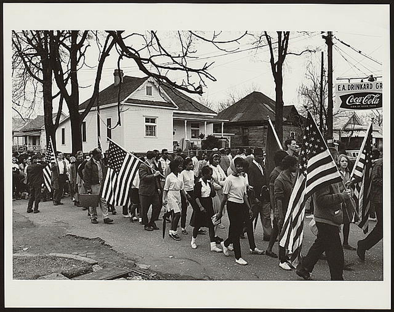 Participants, some carrying American flags, march in the civil rights march from Selma to Montgomery, Alabama in 1965. Photo courtesy of Library of Congress