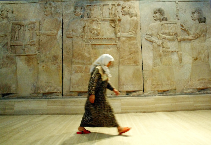 An Iraqi woman walks in front of Assyrian mural sculptures on exhibit in Baghdad in this 2003 photo. One of the most significant archaeological finds of the 20th century, the Nimrud treasures -- excavated in the ancient Assyrian city of Nimrud near present day Mosul-- date back to 900 B.C. and consist of gold artifacts and precious gems. Photo courtesy of REUTERS/Radu Sigheti
HIGH RES: http://archives.religionnews.com/multimedia/photos/rns-isis-nimrud