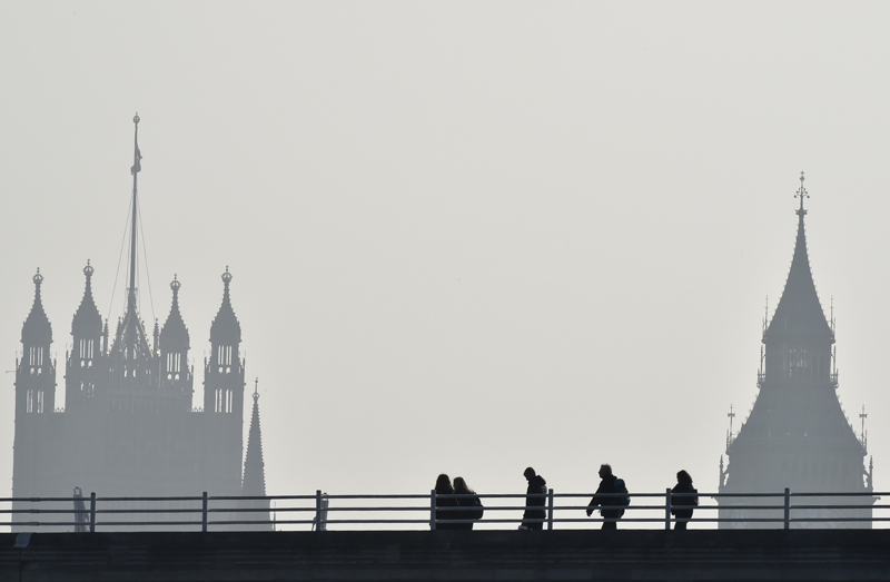 People walk across Waterloo Bridge in front of The Houses of Parliament in London on March 18, 2015. Photo courtesy of REUTERS/Toby Melville 
*Editors: This photo may only be republished with RNS-BRETHREN-SCHOOLS, originally transmitted on March 23, 2015.