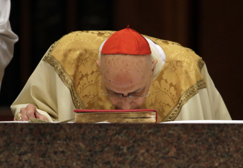 Cardinal Francis George kisses a bible during the Installation Mass of his successor, Archbishop Blase Cupich, at Holy Name Cathedral in Chicago November 18, 2014. Photo courtesy REUTERS/Charles Rex Arbogast. *Editors: This photo can only be used with RNS-GEORGE-OBIT, transmitted April 17, 2015.