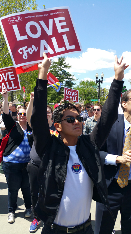 A demonstrator holds up a sign reading "Love For All" outside of the Supreme Court on Tuesday, April 28, 2015, while justices hear arguments about same-sex marriage. Religion News Service photo by Kevin Eckstrom