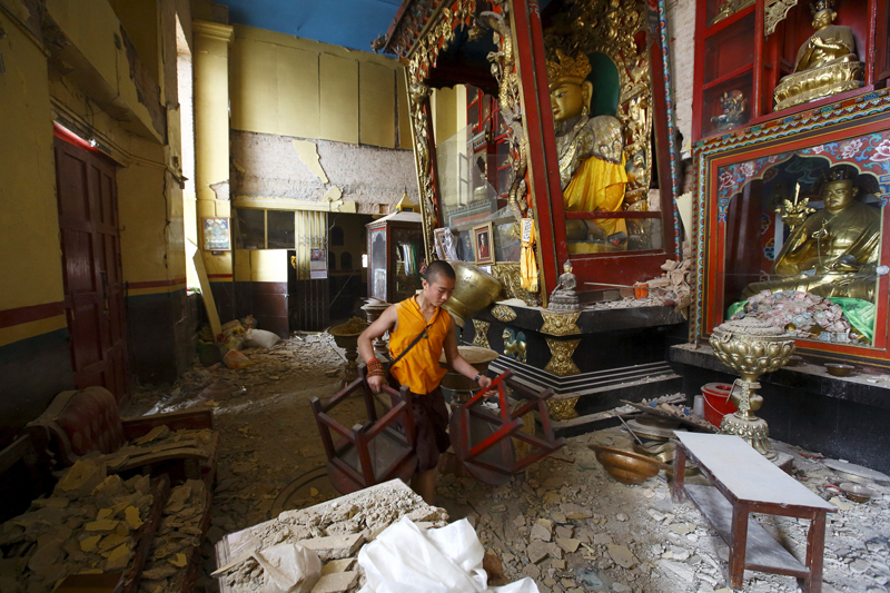  A monk carrying chairs walks out from the damaged monastery at Swoyambhunath Stupa, a UNESCO world heritage site, after Saturday's earthquake in Kathmandu, Nepal on April 28, 2015. Photo courtesy of REUTERS/Navesh Chitrakar *Editors: This photo may only be republished with RNS-SPLAINER-NEPAL, originally transmitted on April 27, 2015.
