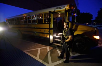 A police officer stands near a school bus used to evacuate attendees of the Muhammad Art Exhibit and Contest sponsored by the American Freedom Defense Initiative after a shooting outside the Curtis Culwell Center where the event was held in Garland, Texas.