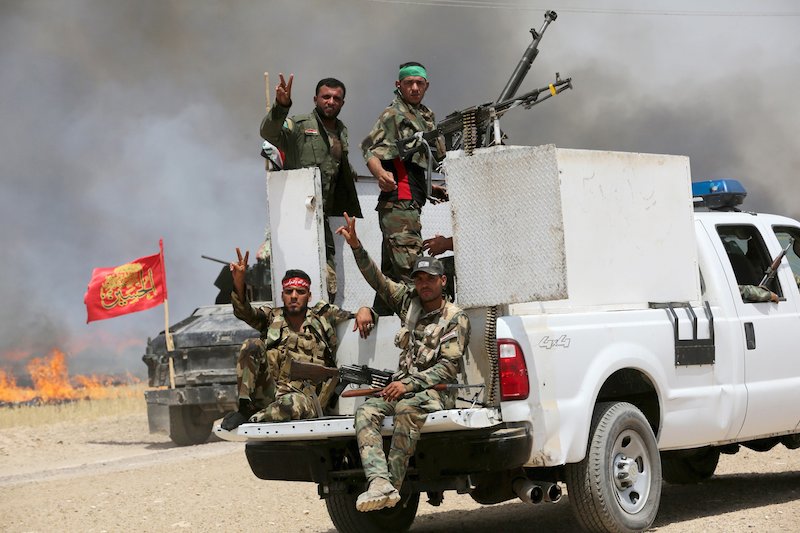 Shi'ite paramilitaries ride in military vehicles in Nibai, May 26, 2015, in effort to push Islamic State out of Sunni heartland of Iraq. Photo courtesy of Reuters. 